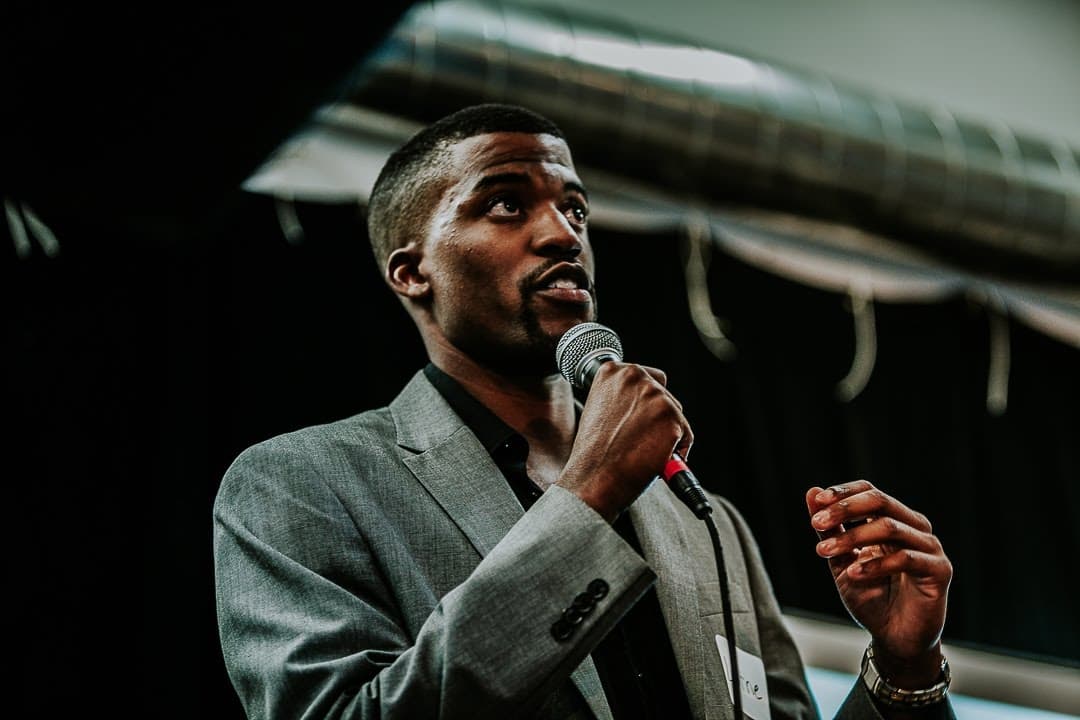 Lorne speaking at event with microphone