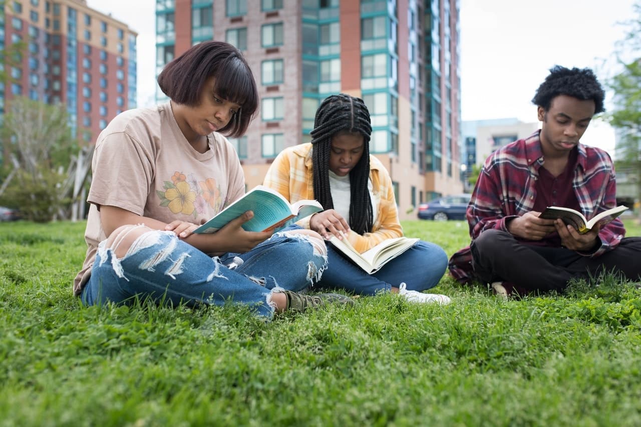 Students reading and learning financial literacy skills outdoors